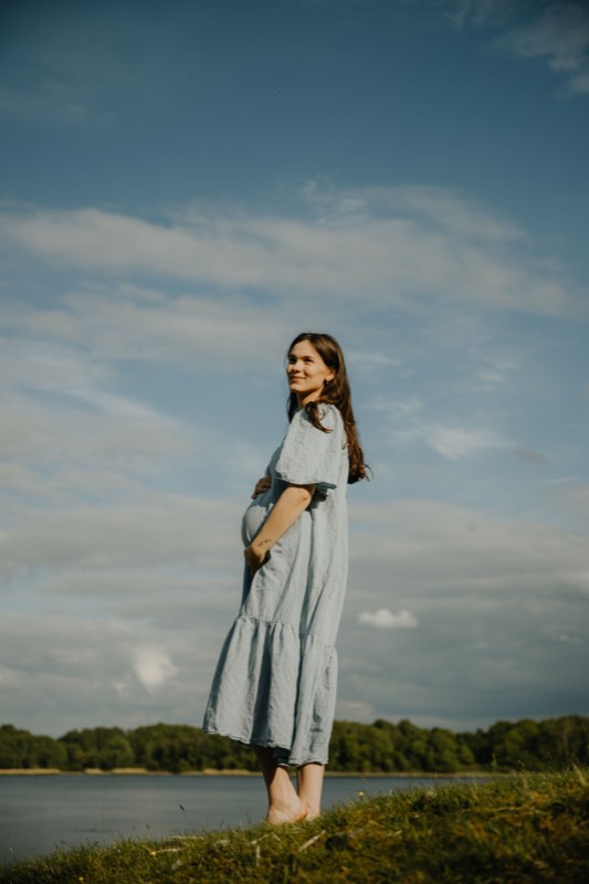 Figur im hellen Kleid am Wasser